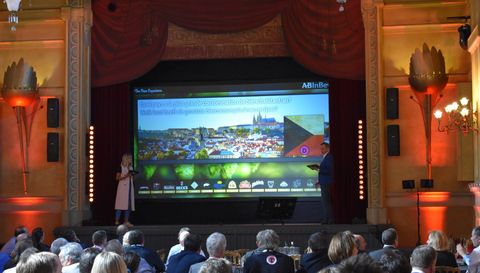 Un théâtre plein, l'écran du quiz sur scène entre les rideaux rouges