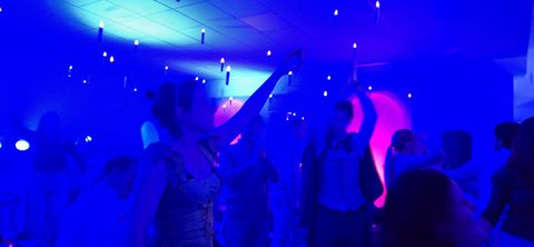Des participants dansent dans la salle plongée dans une lumière bleue