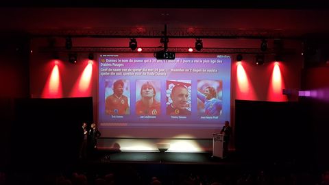 Sur la scène d'un théâtre, une question bilingue français-néerlandais sur les Diables Rouges, aux couleurs d'AB InBev