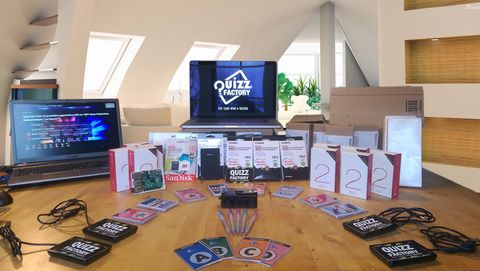 Le matériel Quizz Factory étalé sur une table : buzzers, cartes de réponse A, B, C, D, ordinateurs et écran